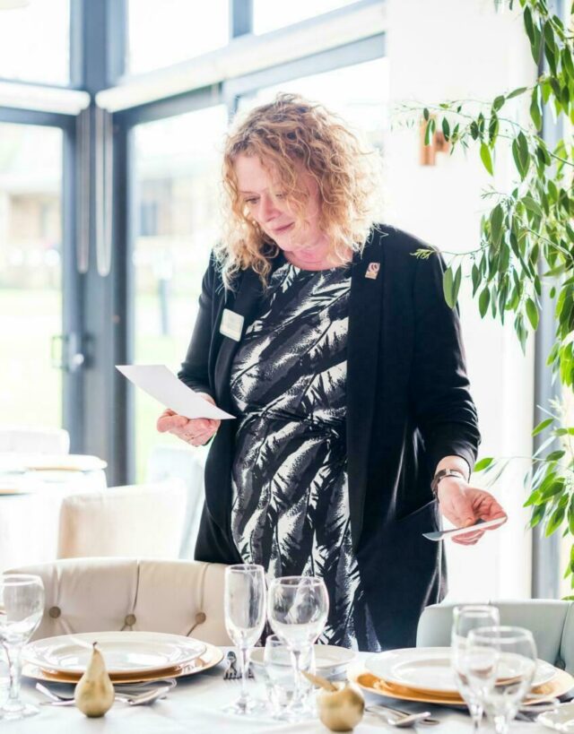 Wedding team member checking a table setting